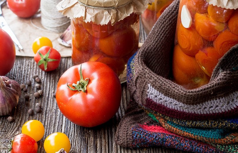 Fresh Tomatoes Beside Jars of Canned Tomatoes