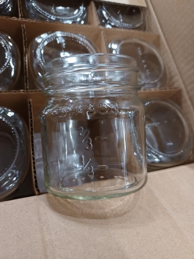 square mason jars in a case with cardboard dividers